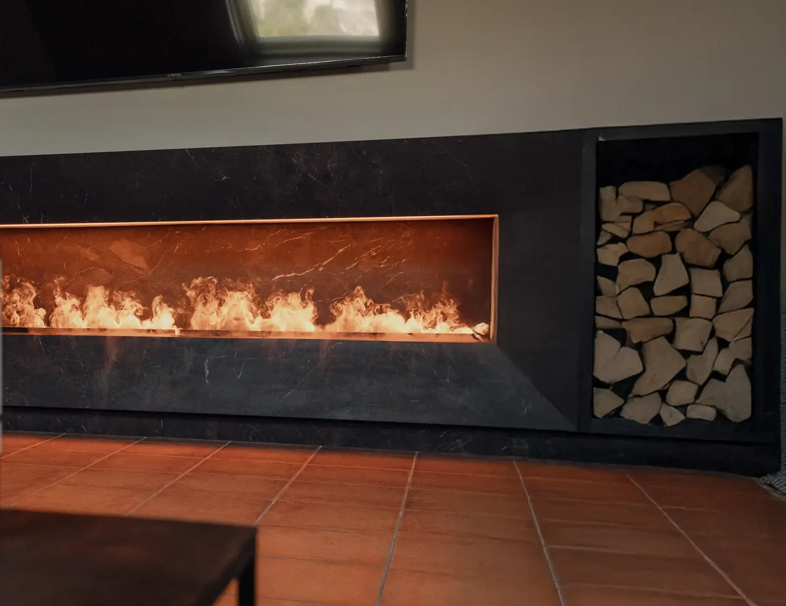 Chimenea encendida junto a la leña
